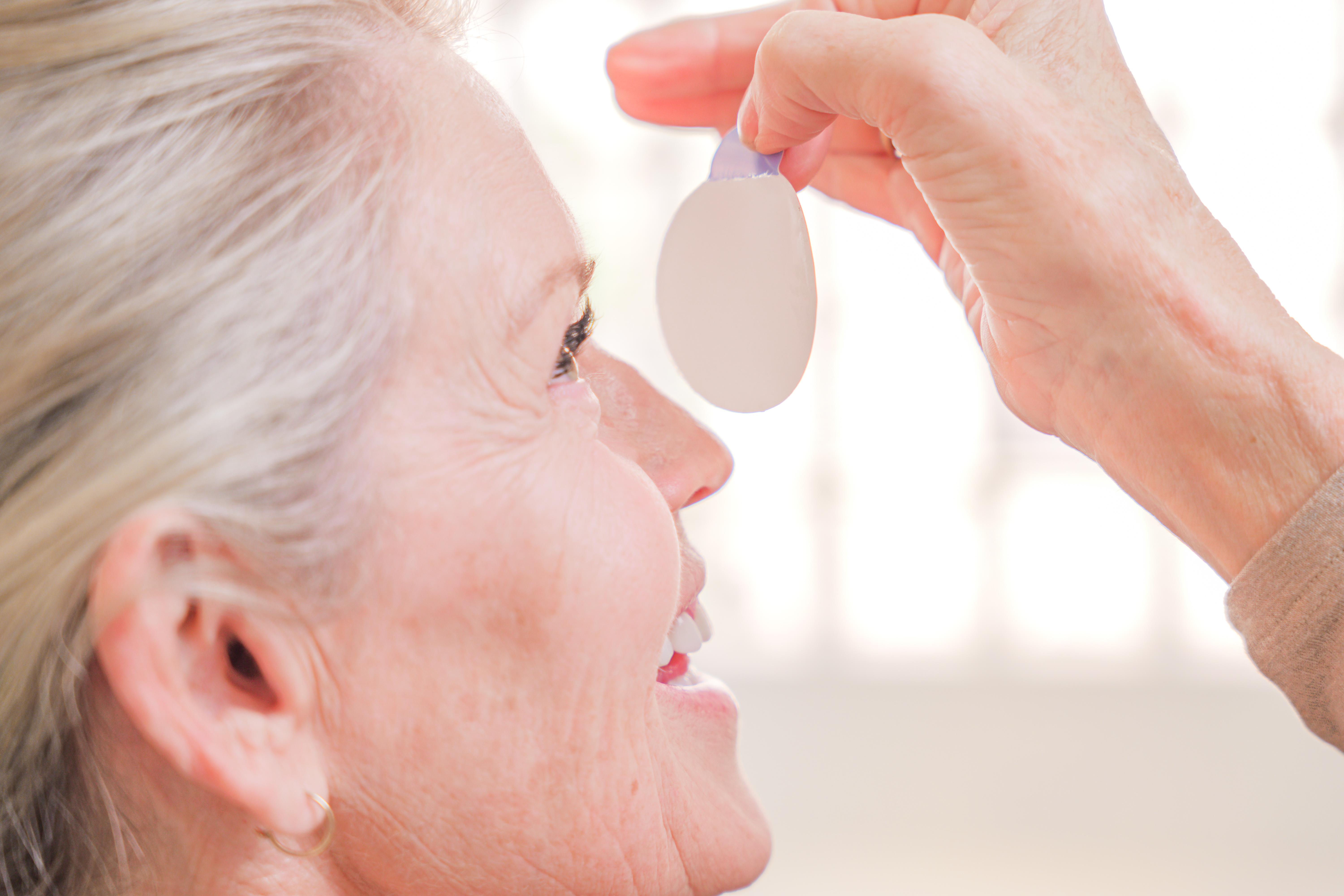 A woman pausing during her day with her eyes closed — the daily reality of dry eye discomfort